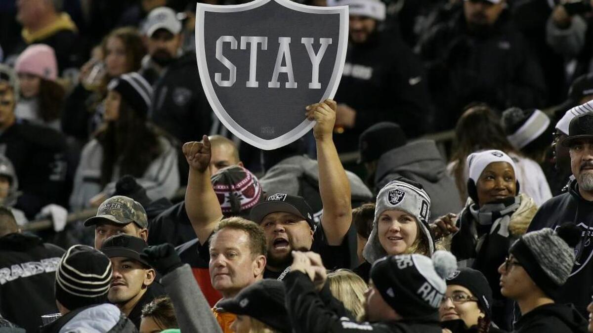 Fans hold up a sign for the Oakland Raiders to stay in Oakland before an NFL football game between against the San Diego Chargers, Thursday, Dec. 24, 2015 in Oakland. Local fans are guardedly optimistic about the team staying in the East Bay.