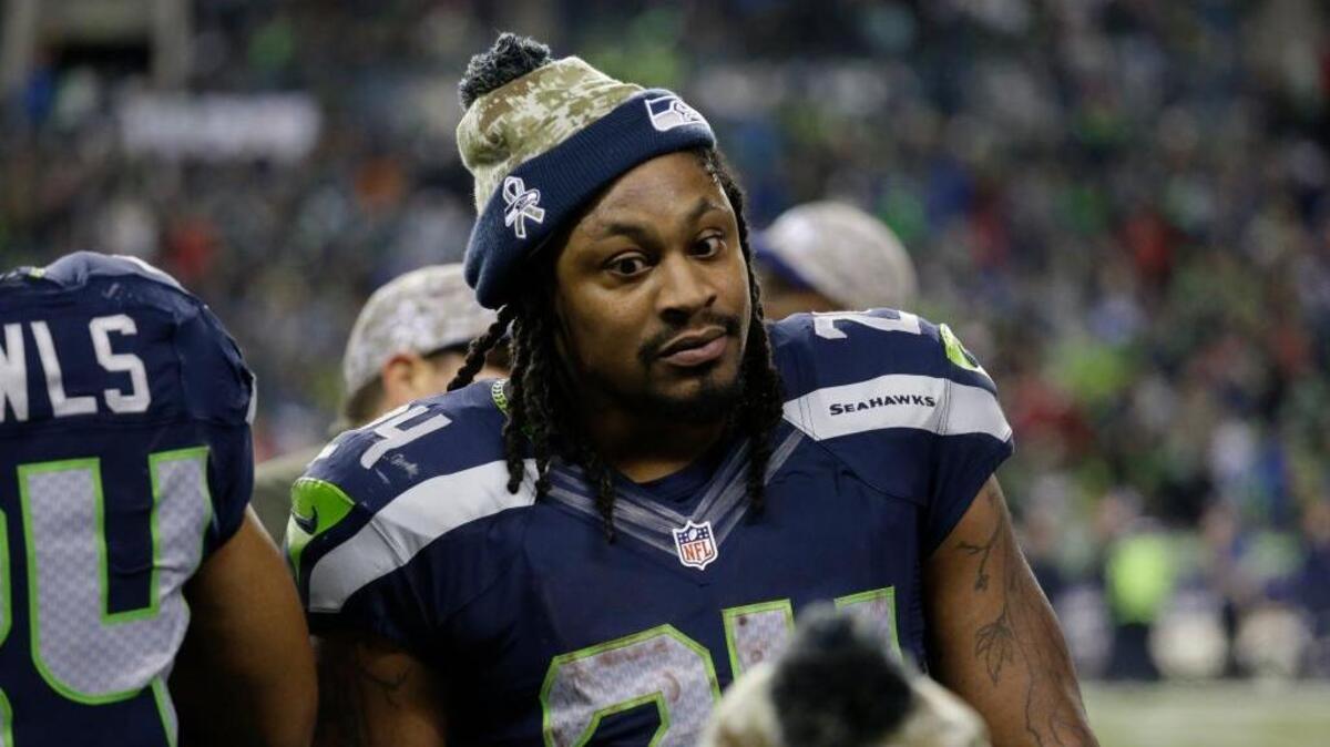 Seattle Seahawks running back Marshawn Lynch talks to teammates on the sideline during a game against the Arizona Cardinals on Nov. 15, 2015, in Seattle. Lynch, who retired at the end of that season, reportedly visited the Raiders on Wednesday in a bid to return to the NFL and play for his hometown team.