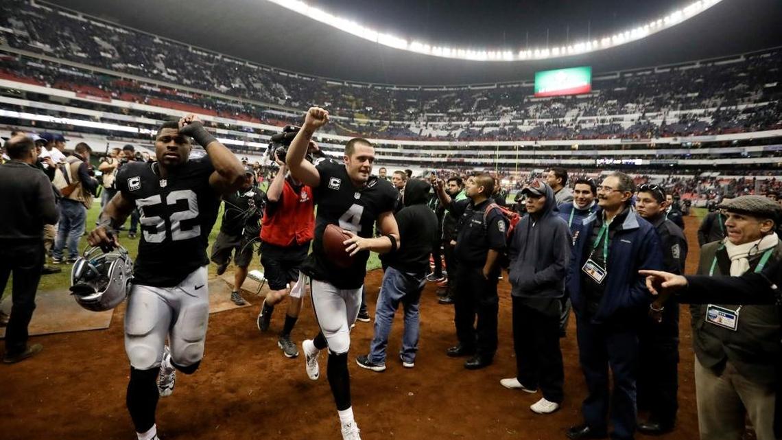 Raiders quarterback Derek Carr, center, and defensive end Khalil Mack (52) celebrate a win over the Houston Texans on Nov. 21, 2016, in Mexico City. The Raiders will return to the Mexican capital this season to face the New England Patriots.