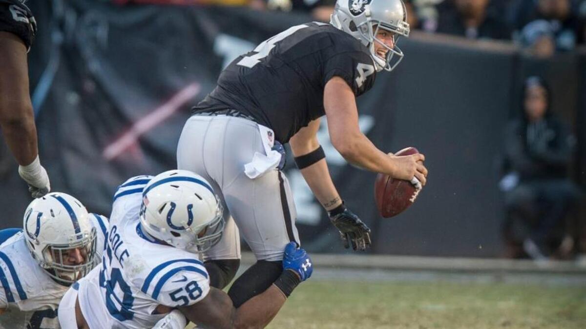 Oakland Raiders quarterback Derek Carr is tackled in the fourth quarter by Indianapolis Colts outside linebacker Trent Cole (58) at Oakland/Alameda County Coliseum in Oakland, Calif., on Saturday, Dec. 24, 2016. Carr’s fibula was broken on the play, ending his season.