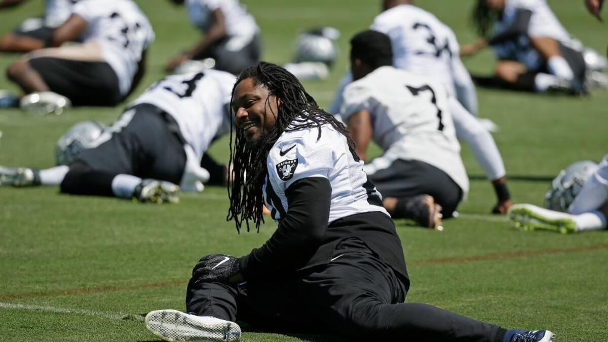 Raiders running back Marshawn Lynch stretches during the team’s OTA practice Tuesday in Alameda. Lynch, who was retired last season before joining Oakland, was mostly an observer during Tuesday’s session.