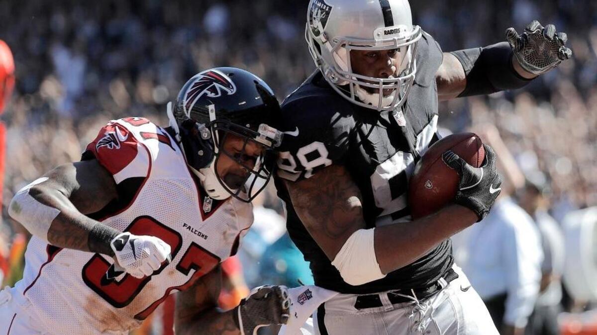 Raiders tight end Clive Walford (88) scores on a touchdown reception in front of Atlanta Falcons free safety Ricardo Allen during the second half of an NFL football game in Oakland on Sunday, Sept. 18, 2016.
