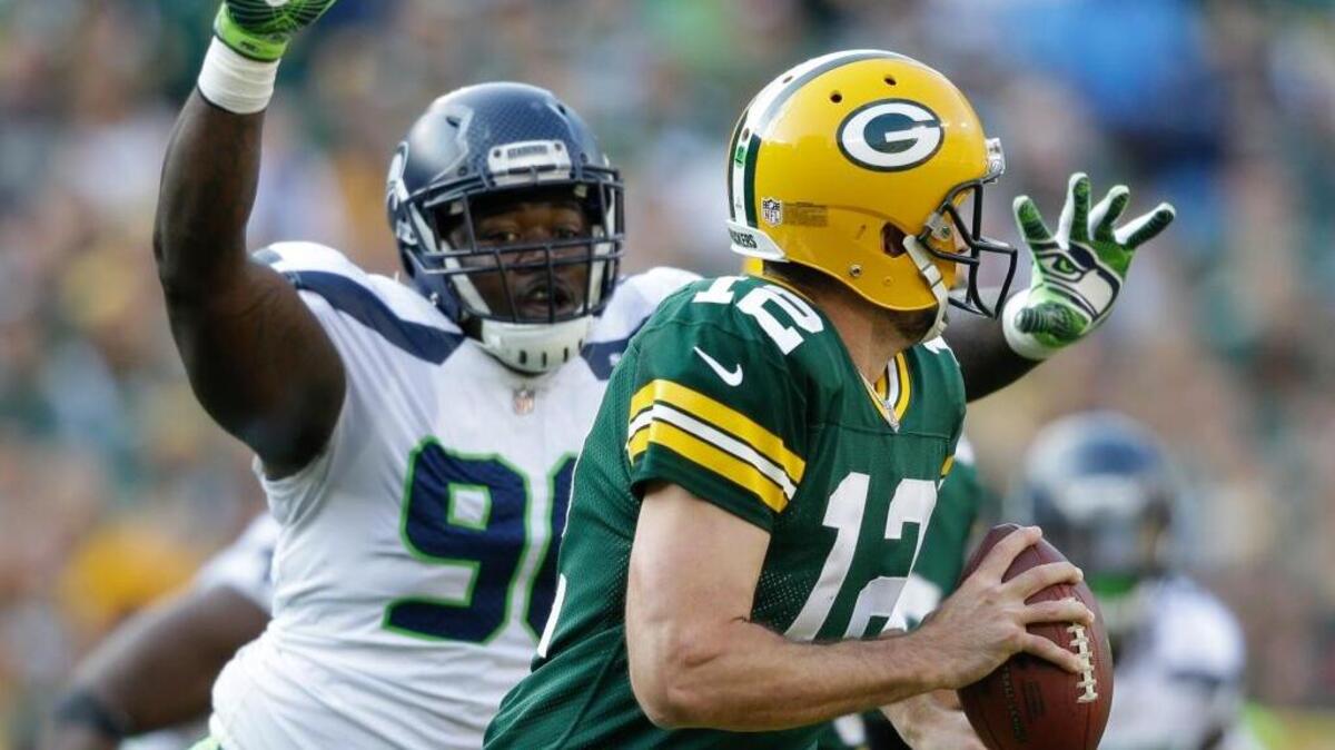 Green Bay Packers’ Aaron Rodgers scrambles past Seattle Seahawks’ Jarran Reed on Sunday in Green Bay, Wis.