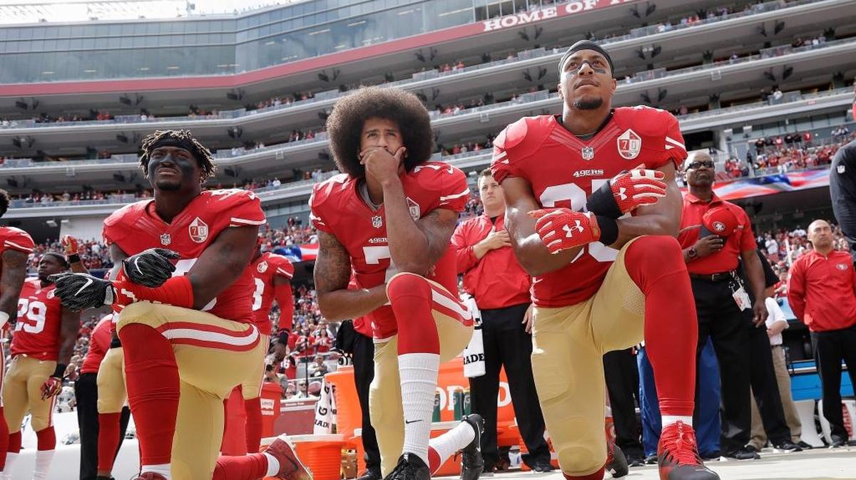 In this Oct. 2, 2016 file photo, from left, San Francisco 49ers outside linebacker Eli Harold, quarterback Colin Kaepernick and safety Eric Reid kneel in protest during the national anthem before an NFL football game against the Dallas Cowboys in Santa Clara, Calif.