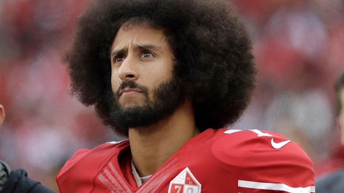FILE - In this Dec. 11, 2016, file photo, San Francisco 49ers quarterback Colin Kaepernick stands in the bench area during the second half of the team's NFL football game against the New York Jets in Santa Clara, Calif.