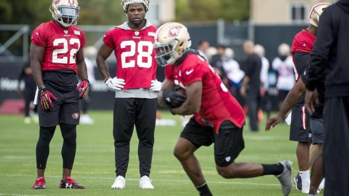 49ers running backs Carlos Hyde (28) and Tim Hightower (22) watch drills during training camp on Thursday in Santa Clara.