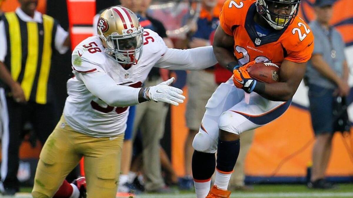 Denver Broncos running back C.J. Anderson (22) gets away from the attempted tackle of San Francisco 49ers outside linebacker Eli Harold (58) during the first half of an NFL preseason football game, Saturday, Aug. 29, 2015, in Denver.