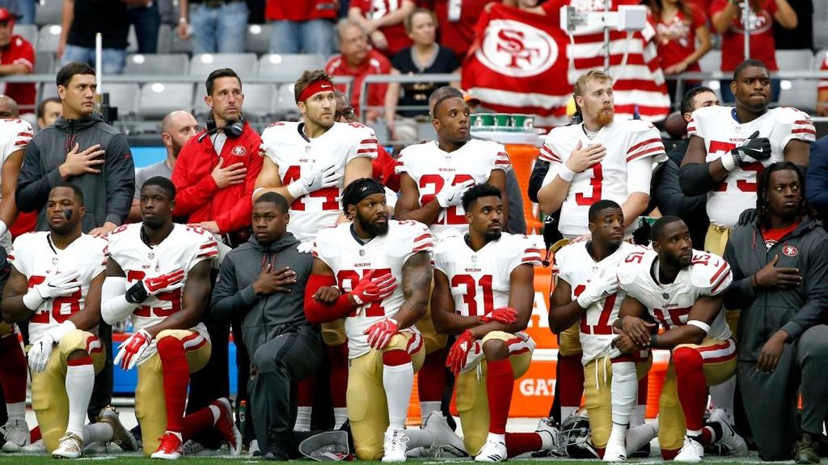 Members of the San Francisco 49ers kneel as others stand during the national anthem prior to an NFL football game against the Arizona Cardinals, Sunday, Oct. 1, 2017, in Glendale, Ariz.