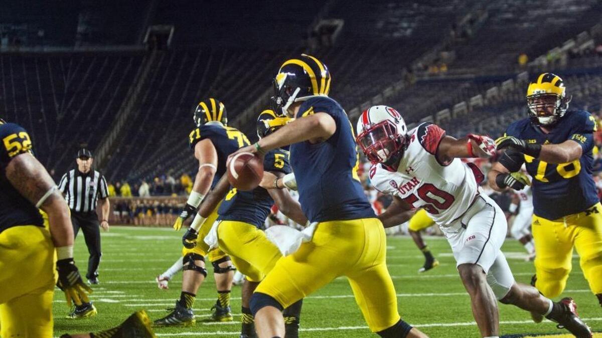 Michigan quarterback Shane Morris, front center, tries to avoid a sack in his own end zone from Utah linebacker Pita Taumoepenu (50) in Ann Arbor, Mich., on Sept. 20, 2014.