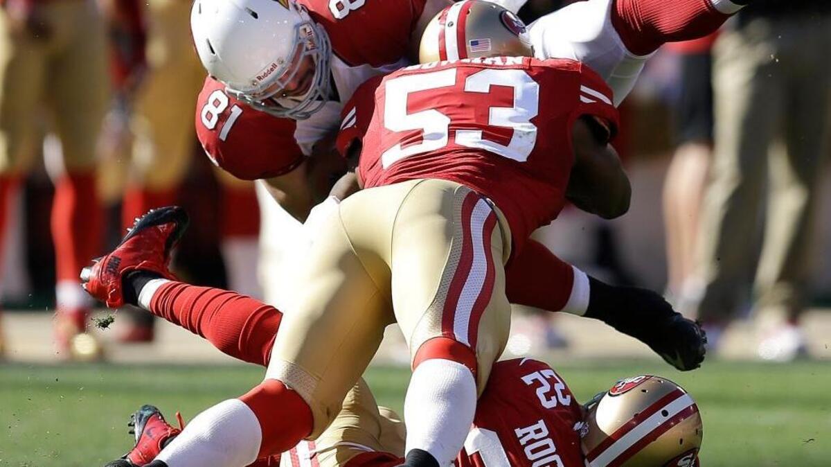 Arizona Cardinals tight end Jim Dray (81) is tackled by San Francisco 49ers linebacker NaVorro Bowman (53) as he jumps over cornerback Carlos Rogers (22) during the third quarter of an NFL football game in San Francisco, Sunday, Oct. 13, 2013.