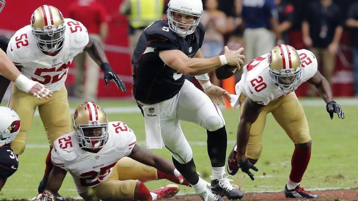 Arizona Cardinals quarterback Drew Stanton (5) tries to escape the reach of San Francisco 49ers cornerback Perrish Cox (20), Patrick Willis (52) and Jimmie Ward (25) during the first half of an NFL football game, Sunday, Sept. 21, 2014, in Glendale, Ariz.