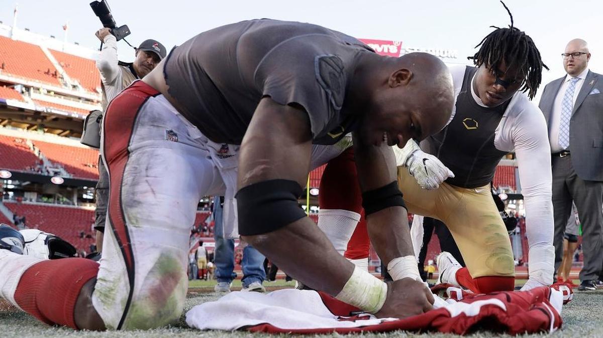 Arizona Cardinals running back Adrian Peterson, foreground, signs a jersey for 49ers linebacker Reuben Foster after Sunday’s game in Santa Clara.