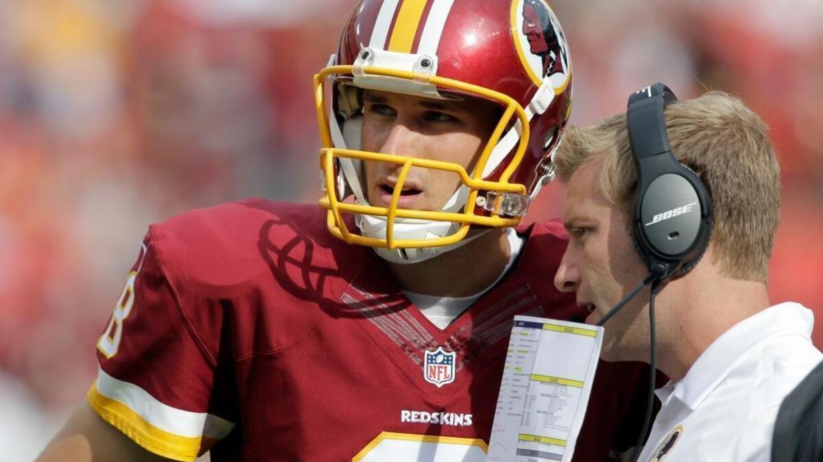 Washington Redskins quarterback Kirk Cousins (8) listens to offensive coordinator Sean McVay, during the second half of an NFL football game against the Jacksonville Jaguars Sunday, Sept. 14, 2014, in Landover, Md. The Redskins won 41-10.