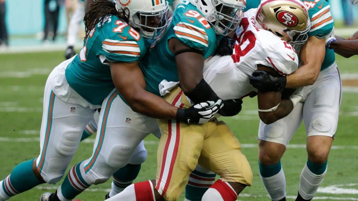San Francisco 49ers running back Carlos Hyde (28) is tackled by Miami Dolphins defensive tackle Earl Mitchell (90), defensive tackle Nick Williams (75) and middle linebacker Kiko Alonso (47), during the first half of an NFL football game, Sunday, Nov. 27, 2016, in Miami Gardens, Fla.