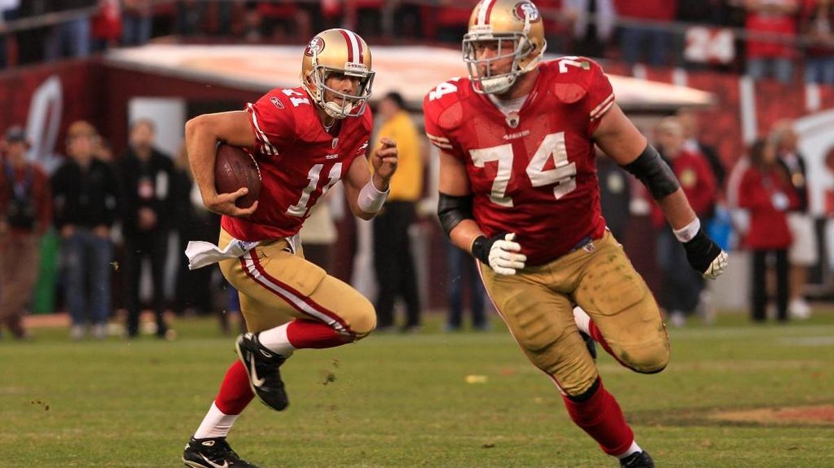 In this photo from Jan. 14, 2012, San Francisco 49ers quarterback Alex Smith (11) runs behind offensive tackle Joe Staley (74) to score on a 28-yard touchdown run during the fourth quarter of an NFL divisional playoff football game against the New Orleans Saints in San Francisco.