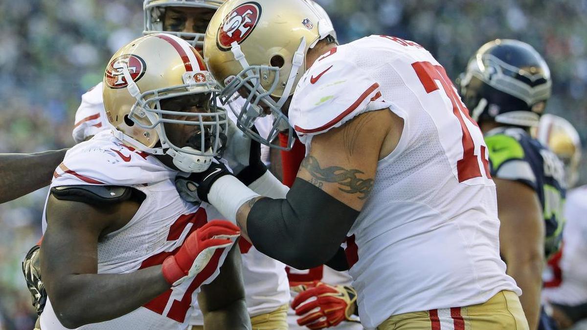 San Francisco 49ers running back Frank Gore, left, celebrates with teammate Alex Boone, right, after Gore scored a touchdown against the Seattle Seahawks in the first half of an NFL football game, Sunday, Dec. 14, 2014, in Seattle.