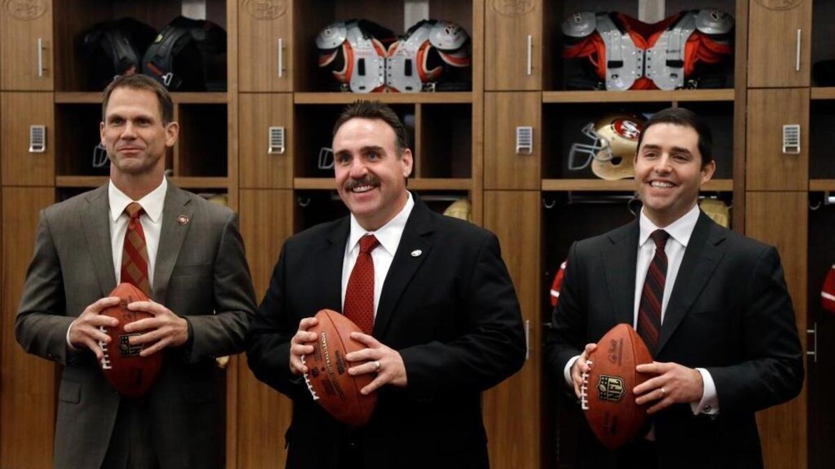 San Francisco 49ers coach Jim Tomsula, center, poses for photos with general manager Trent Baalke, left, and team owner Jed York, right, after an NFL football news conference announcing Tomsula's hiring, Thursday, Jan. 15, 2015, in Santa Clara, Calif.