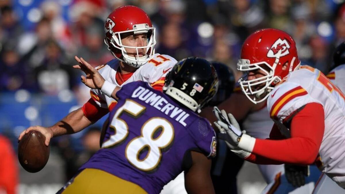 Kansas City Chiefs quarterback Alex Smith (11) throws to a receiver as he is pressured by Baltimore Ravens outside linebacker Elvis Dumervil in the first half of an NFL football game, Sunday, Dec. 20, 2015, in Baltimore.