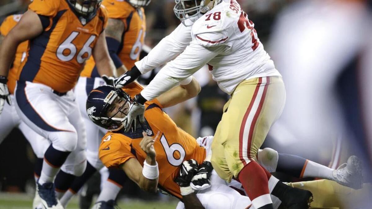 Denver Broncos quarterback Mark Sanchez (6) is pushed down by San Francisco 49ers' Garrison Smith, right, after Sanchez fumbled in the first half of a preseason NFL football game, Saturday, Aug. 20, 2016, in Denver.