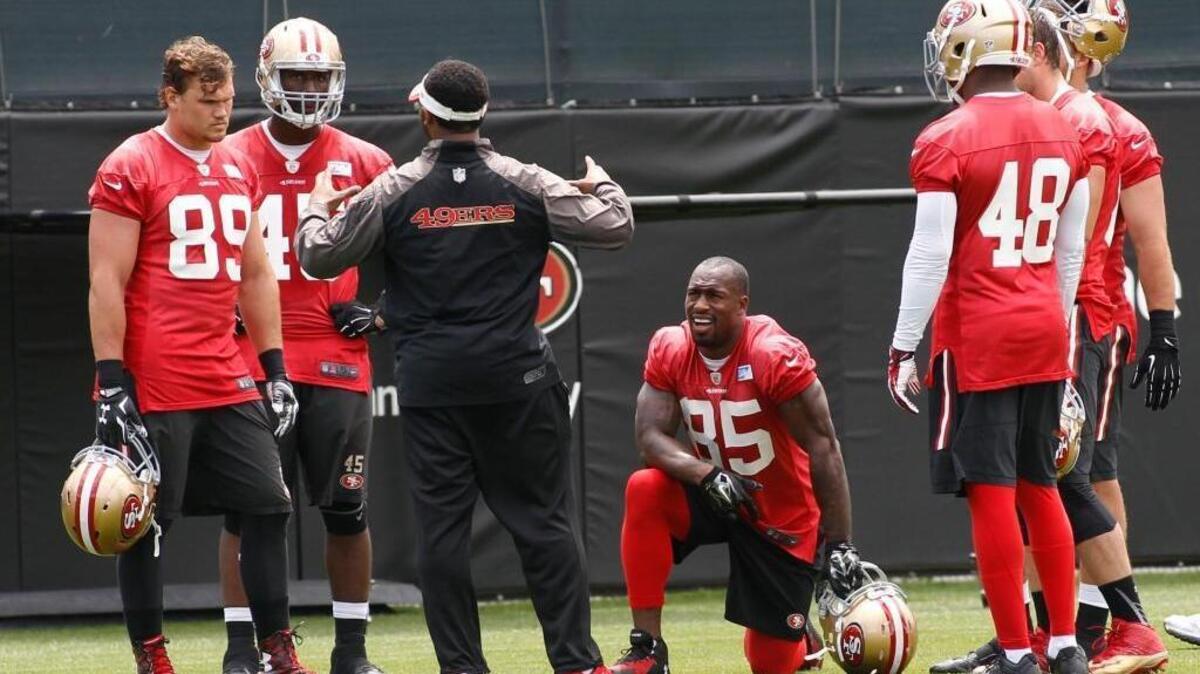 San Francisco 49ers' Vernon Davis (85), center, and teammates listen to a coach during NFL football practice, Thursday, May 21, 2015, in Santa Clara, Calif.