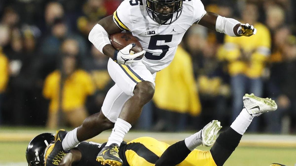 Michigan’s Jabrill Peppers (5) breaks a tackle attempt by Iowa defensive back Desmond King on Nov. 12 in Iowa City, Iowa.