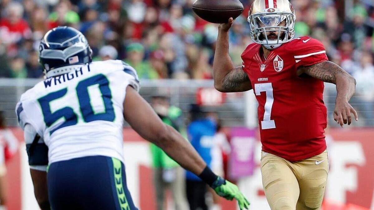 Colin Kaepernick, right, passes under pressure from Seattle outside linebacker K.J. Wright during the first half at Levi’s Stadium in Santa Clara, Calif., on Sunday, Jan. 1, 2017.