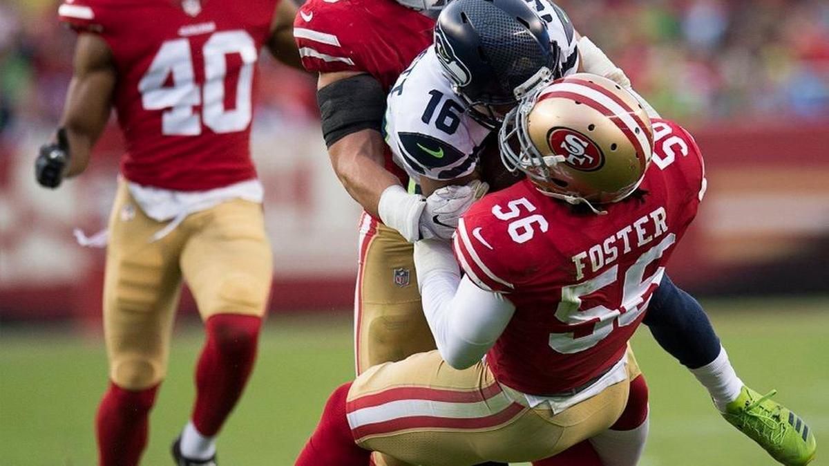 San Francisco 49ers middle linebacker Brock Coyle (50) andSan Francisco 49ers outside linebacker Reuben Foster (56) tackle Seattle Seahawks wide receiver Tyler Lockett (16) in the first quarter during the game at Levi's Stadium in Santa Clara, Calif. on Sunday November 26, 2017.