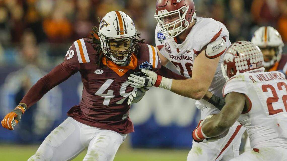 Virginia Tech’s Tremaine Edmunds, left, tries to work his way out of a block by Arkansas’ Dan Skipper for a chance to tackle Rawleigh Williams III (22) during the Belk Bowl on Dec. 29, 2016.