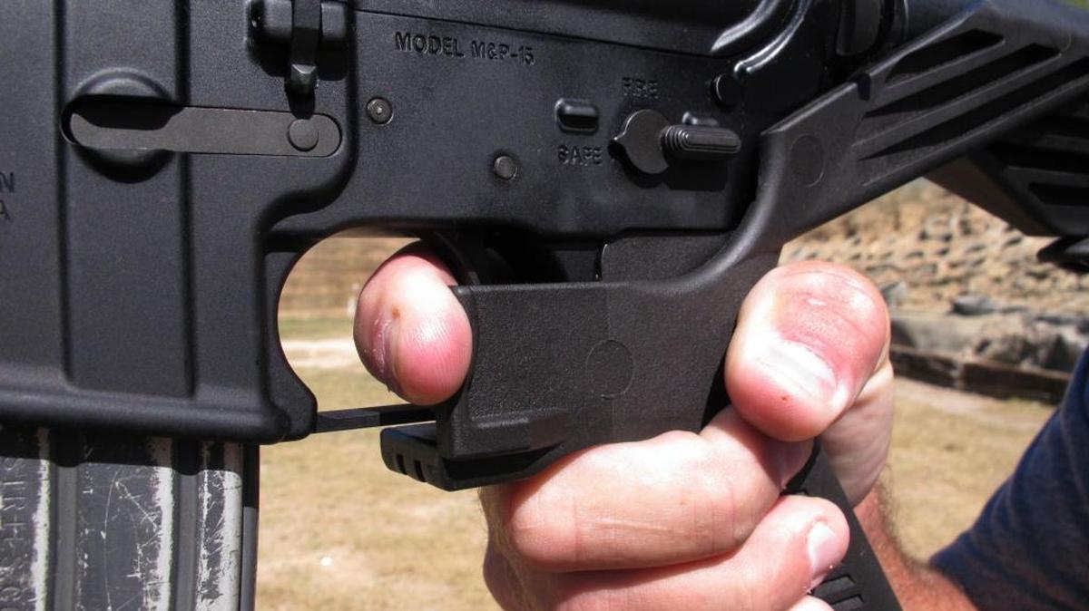 FILE - In this Oct. 4, 2017, file photo, shooting instructor Frankie McRae demonstrates the grip on an AR-15 rifle fitted with a bump stock at his 37 PSR Gun Club in Bunnlevel, N.C. Massachusetts is on its way to becoming the first state since the Las Vegas shooting massacre to outlaw devices that allow semi-automatic weapons to mimic fully automatic guns. The Massachusetts Senate voted 33-0 on Thursday, Oct. 12, to ban the sale of bump stocks and trigger cranks, attachments that increase the firing rate of a weapon.