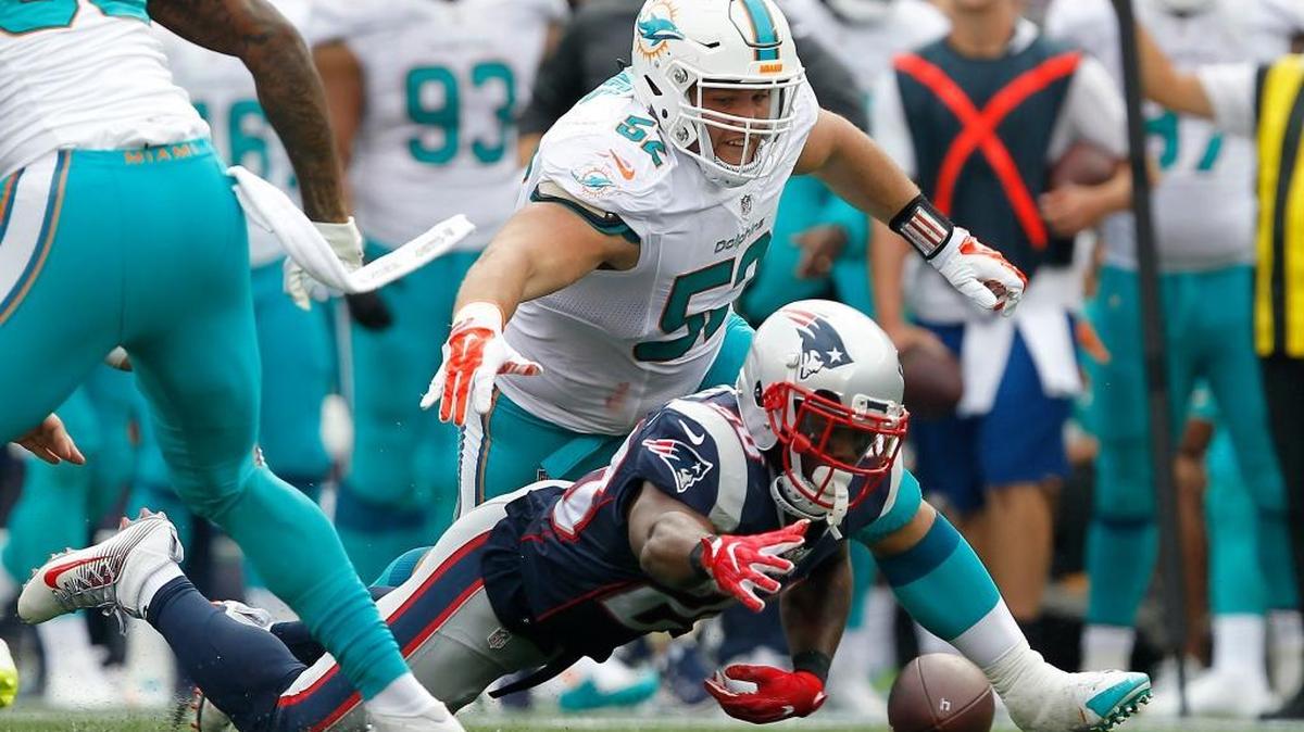 New England Patriots running back James White (28) recovers a fumble by New England Patriots quarterback Jacoby Brissett (not pictured) as Miami Dolphins defensive tackle Chris Jones (52) looks to recover the ball during the second half of an NFL football game Sunday, Sept. 18, 2016, in Foxborough, Mass.