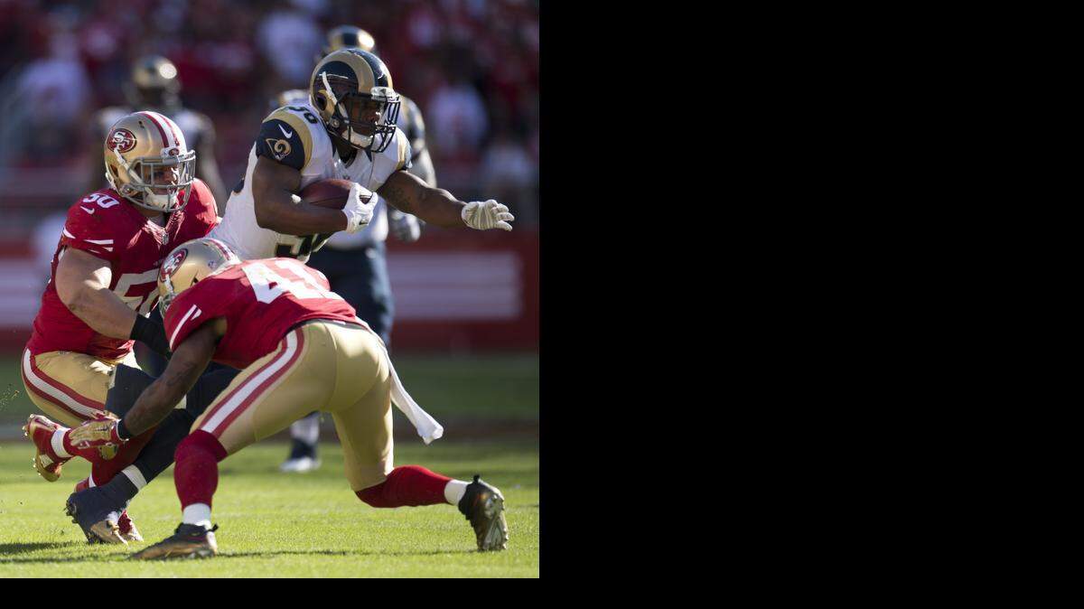 
Rams running back Benny Cunningham is tackled by Chris Borland, left, and Antoine Bethea of the 49ers.


