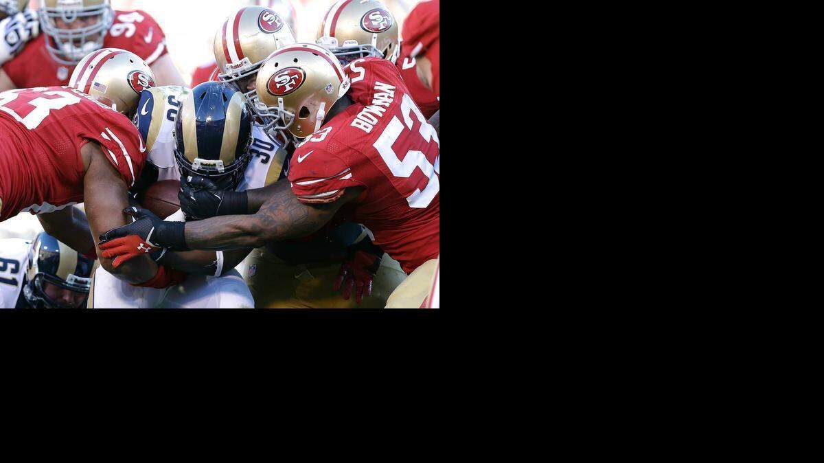 
NaVorro Bowman teams with Tony Jerod-Eddie to take down a Rams runner in 2013.
