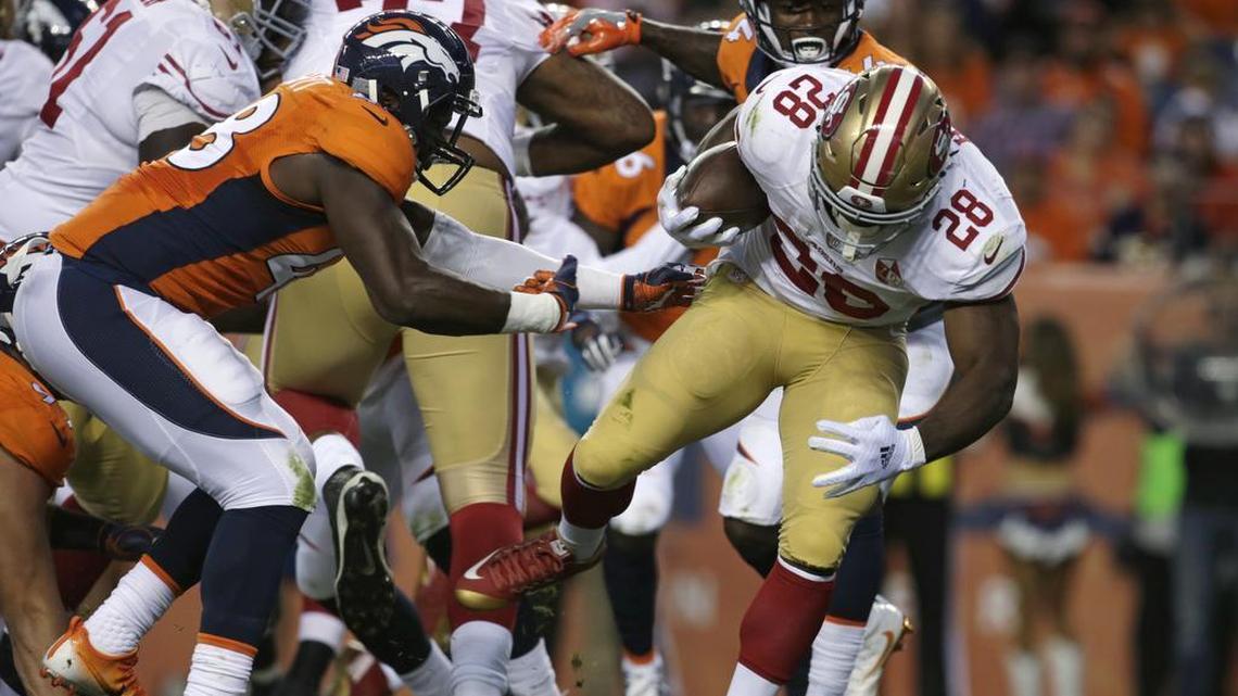 49ers running back Carlos Hyde breaks a tackle from Denver Broncos outside linebacker Shaquil Barrett, left, to score a touchdown during the first half of a preseason NFL football game, Saturday, Aug. 20, 2016, in Denver.