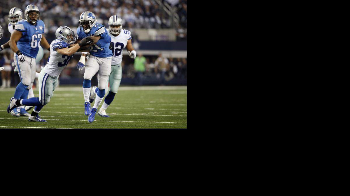 
Dallas Cowboys' Jeff Heath (38) wraps up Detroit Lions' Reggie Bush (21) during after a short gain by Bush in an NFL football game, Sunday, Jan. 4, 2015, in Arlington, Texas.
