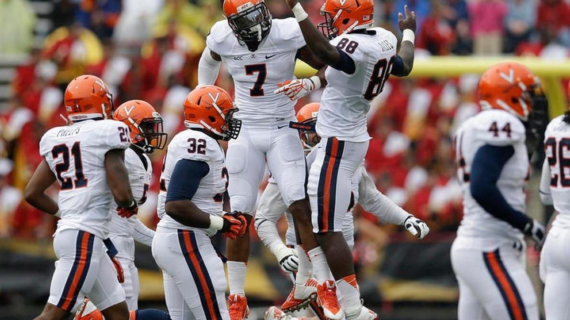 
Virginia defensive ends Eli Harold (7) and Max Valles (88) celebrate after Harold recovered a fumble by Maryland quarterback Caleb Rowe in the first half of an NCAA college football game in College Park, Md., Saturday, Oct. 12, 2013.

