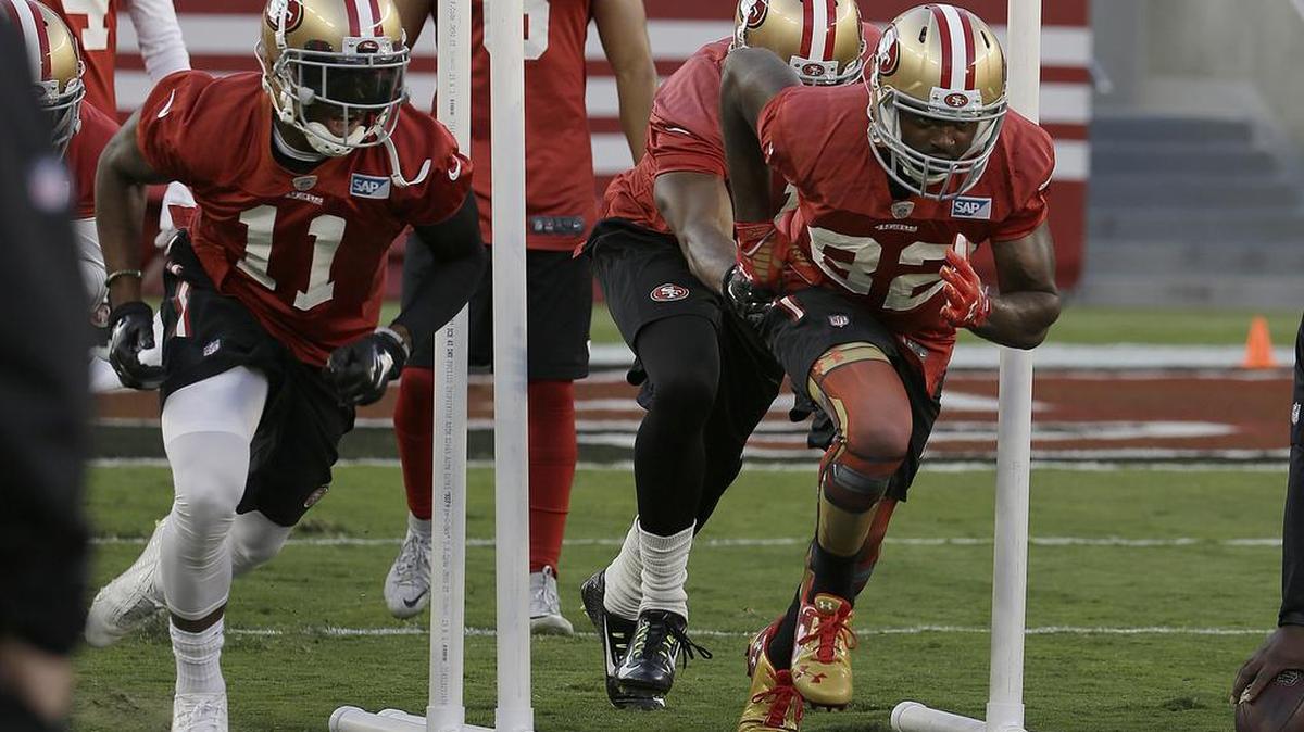 
San Francisco 49ers wide receivers Quinton Patton (11) and Torrey Smith go through a drill at the team’s training camp in Santa Clara on Saturday.
