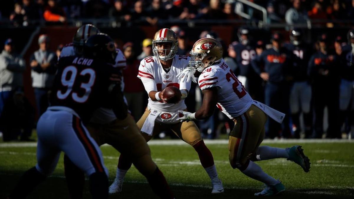 San Francisco 49ers quarterback Jimmy Garoppolo, center, hands off the ball to running back Carlos Hyde during Sunday’s game against the Bears in Chicago.