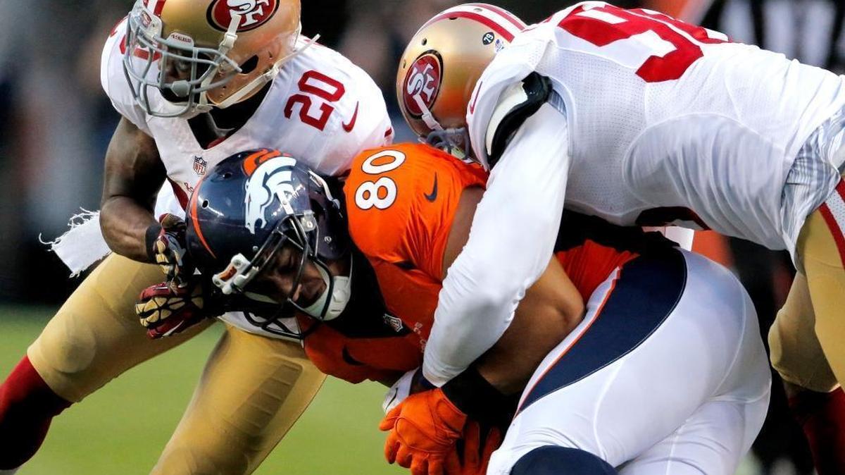 
Denver Broncos tight end James Casey (80) is hit by San Francisco 49ers cornerback Kenneth Acker (20) and Corey Lemonier (96) during the first half of an NFL preseason football game, Saturday, Aug. 29, 2015, in Denver. 
