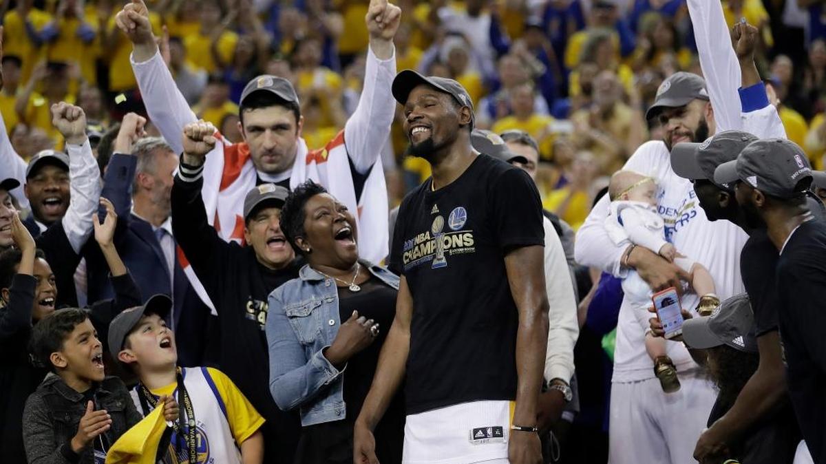 Golden State Warriors forward Kevin Durant, center, celebrates with his mother, Wanda Durant, as he is named the NBA Finals Most Valuable Player on Monday in Oakland. The Warriors beat the Cleveland Cavaliers to win the championship.