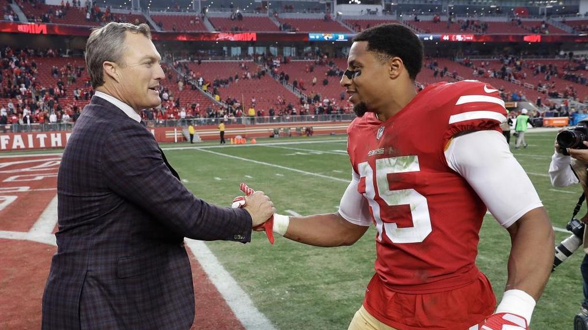 San Francisco 49ers general manager John Lynch, left, greets safety Eric Reid (35) after the 49ers beat the Jacksonville Jaguars in an NFL football game in Santa Clara, Calif., Sunday, Dec. 24, 2017.