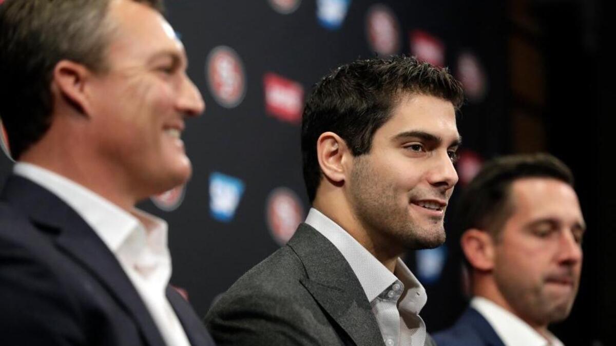 San Francisco 49ers quarterback Jimmy Garoppolo, center, fields questions alongside general manager John Lynch, left, and head coach Kyle Shanahan during an NFL football press conference Friday, Feb. 9, 2018, in Santa Clara, Calif. Garoppolo has signed a five-year contract with the 49ers worth a record-breaking $137.5 million.