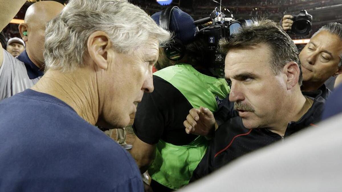 Seattle Seahawks head coach Pete Carroll, left, talks with San Francisco 49ers head coach Jim Tomsula after an NFL football game in Santa Clara, Calif., Thursday, Oct. 22, 2015. The Seahawks won 20-3.