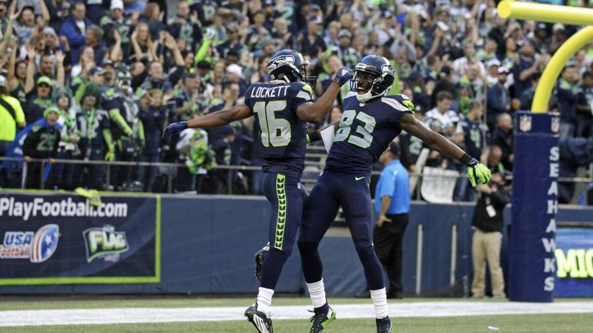
Seattle Seahawks wide receiver Tyler Lockett (16) celebrates with teammate Ricardo Lockette (83) after Lockett ran for a touchdown after catching a pass from quarterback Russell Wilson in the first half of a preseason NFL football game against the Oakland Raiders, Thursday, Sept. 3, 2015, in Seattle. 
