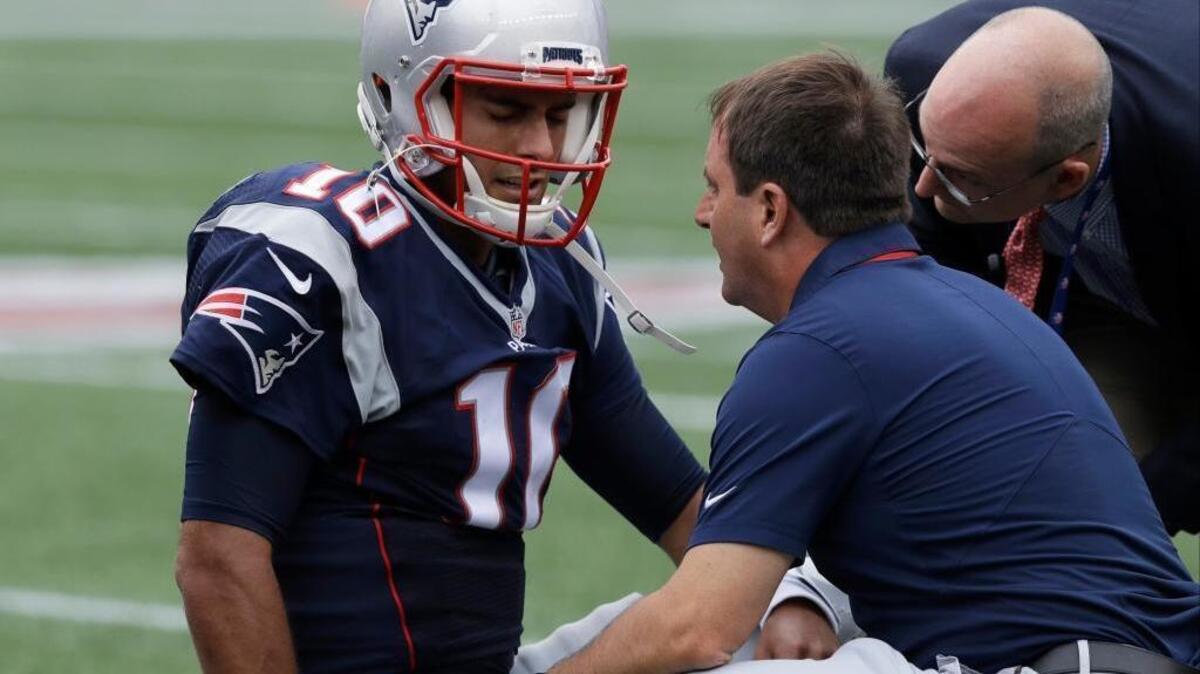 New England Patriots quarterback Jimmy Garoppolo receives attention after an injury during the first half of an NFL football game against the Miami Dolphins, Sunday, Sept. 18, 2016, in Foxborough, Mass.
