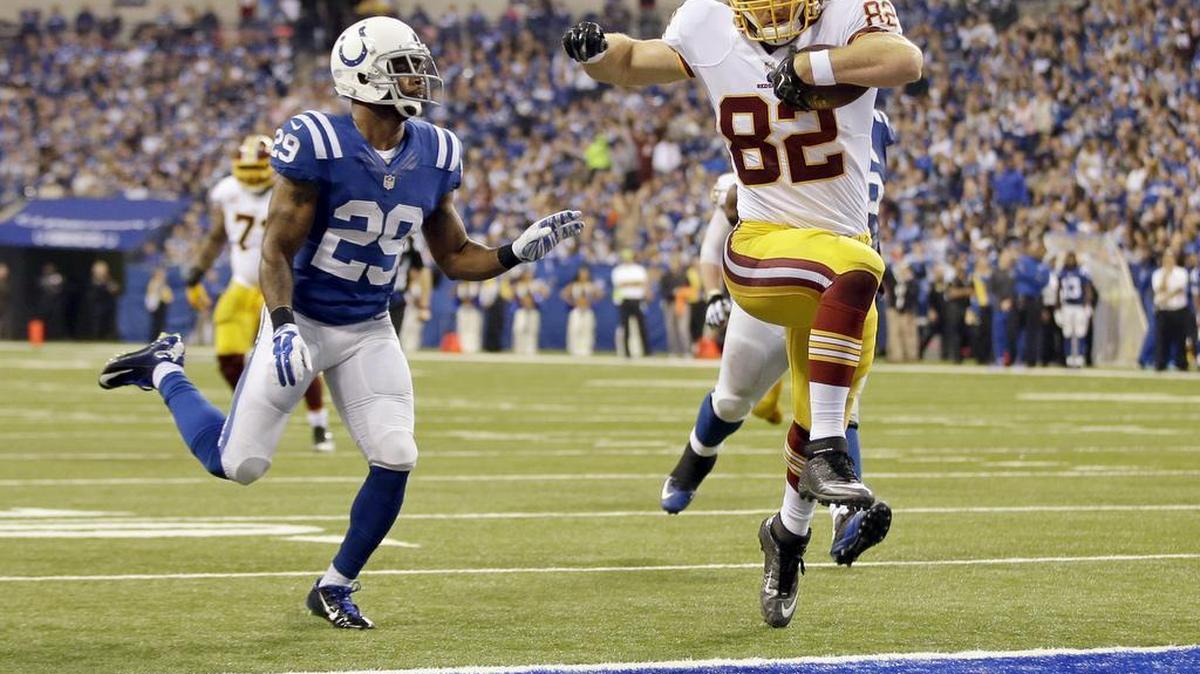 Washington Redskins tight end Logan Paulsen leaps into the end zone for a touchdown in front of Indianapolis Colts strong safety Mike Adams during the second half of an NFL football game Sunday, Nov. 30, 2014, in Indianapolis.
