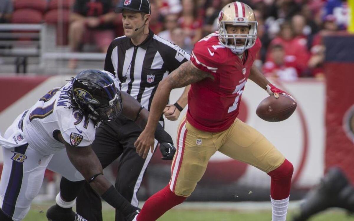 
Colin Kaepernick scrambles away from Baltimore outside linebacker Courtney Upshaw in the second quarter on Sunday.
