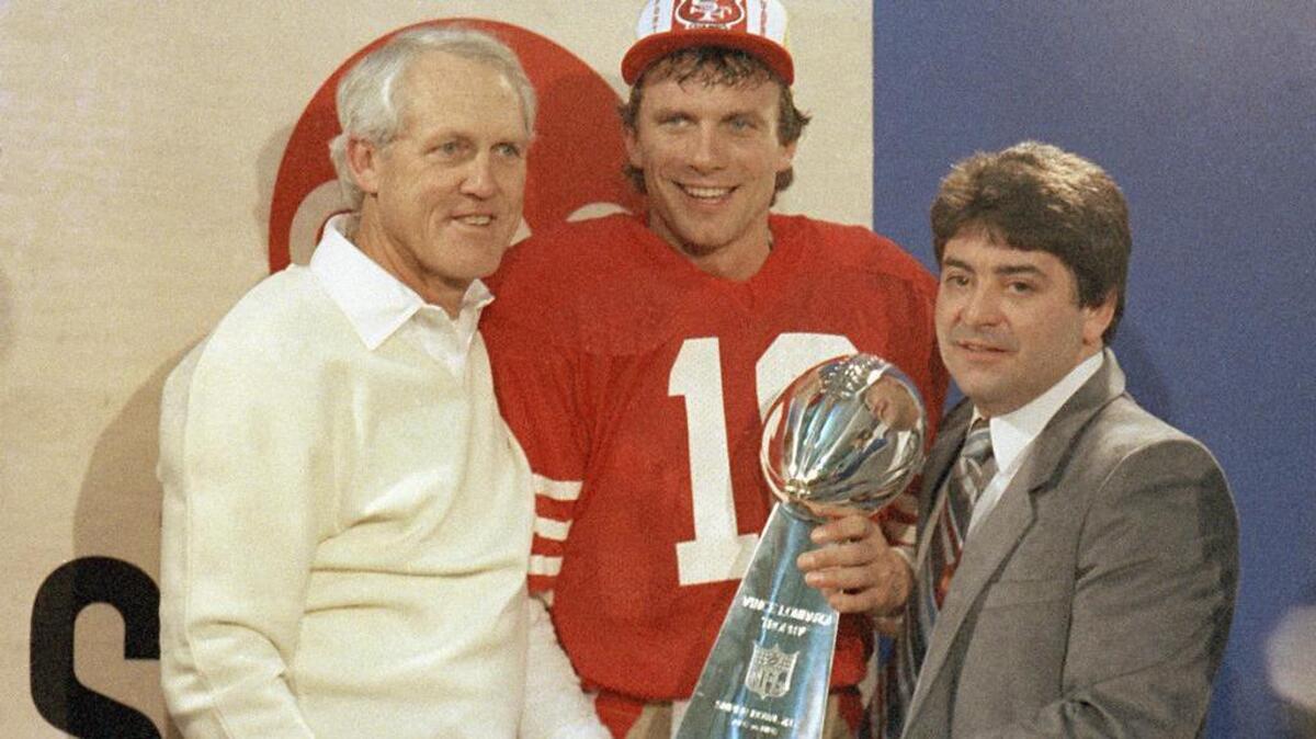 Then-owner Eddie DeBartolo Jr. , right, poses with coach Bill Walsh, quarterback Joe Montana and the Lombardi Trophy after the 49ers’ 1985 Super Bowl win at Stanford.