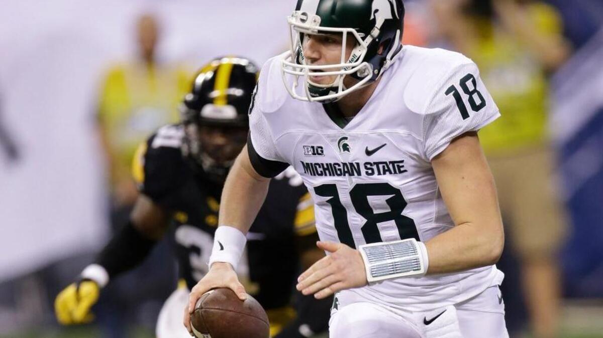 Michigan State quarterback Connor Cook (18) scrambles out of the pocket against Iowa during the first half of the Big Ten Conference championship NCAA college football game Saturday, Dec. 5, 2015, in Indianapolis.