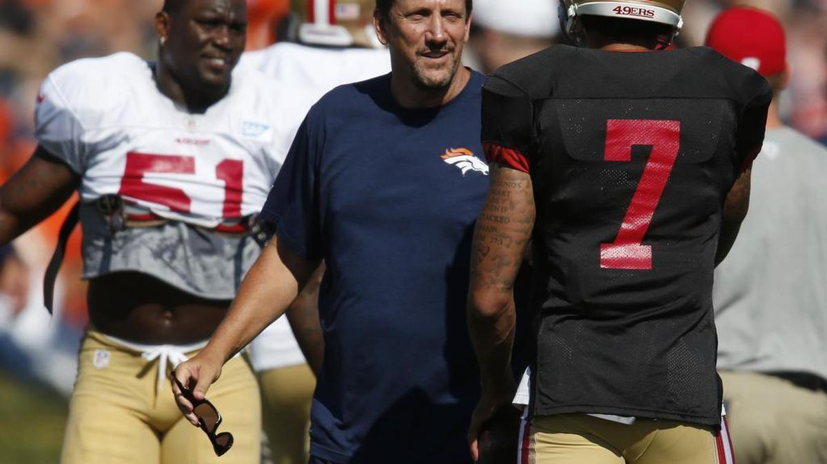 Denver Broncos quarterbacks coach Greg Knapp, center, jokes with San Francisco 49ers quarterback Colin Kaepernick on Aug. 17, 2016. Knapp was seriously injured in a bike crash over the weekend near his home.