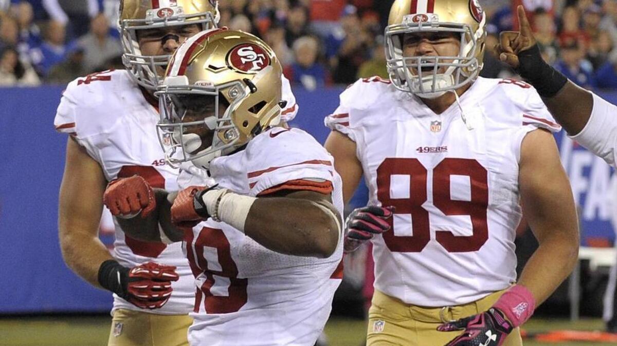 
49ers running back Carlos Hyde (28) celebrates with teammates after scoring a touchdown against the N.Y. Giants during the fourth quarter on Sunday, Oct. 11, 2015, in East Rutherford, N.J. 
